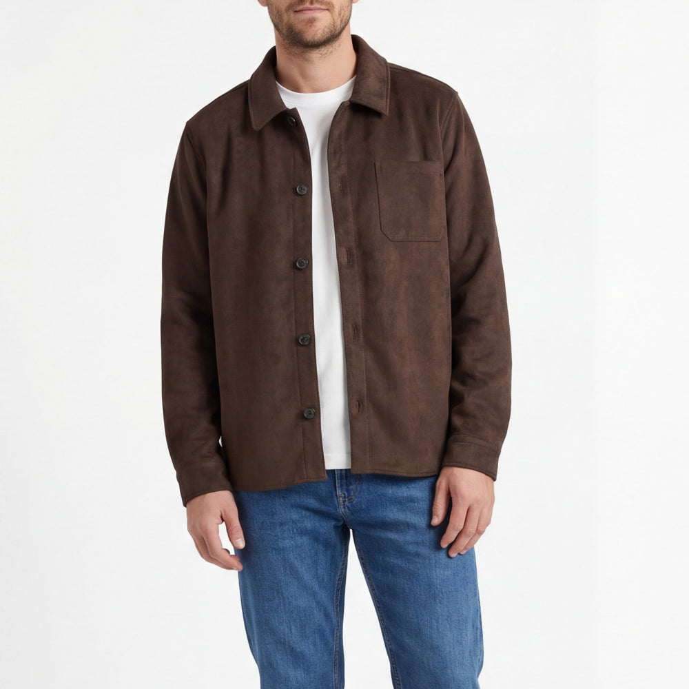 Man wearing a brown jacket over a white shirt and blue jeans on a white background